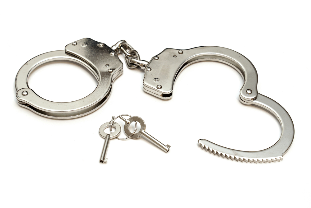 An isolated shot of a pair of police quality handcuffs.