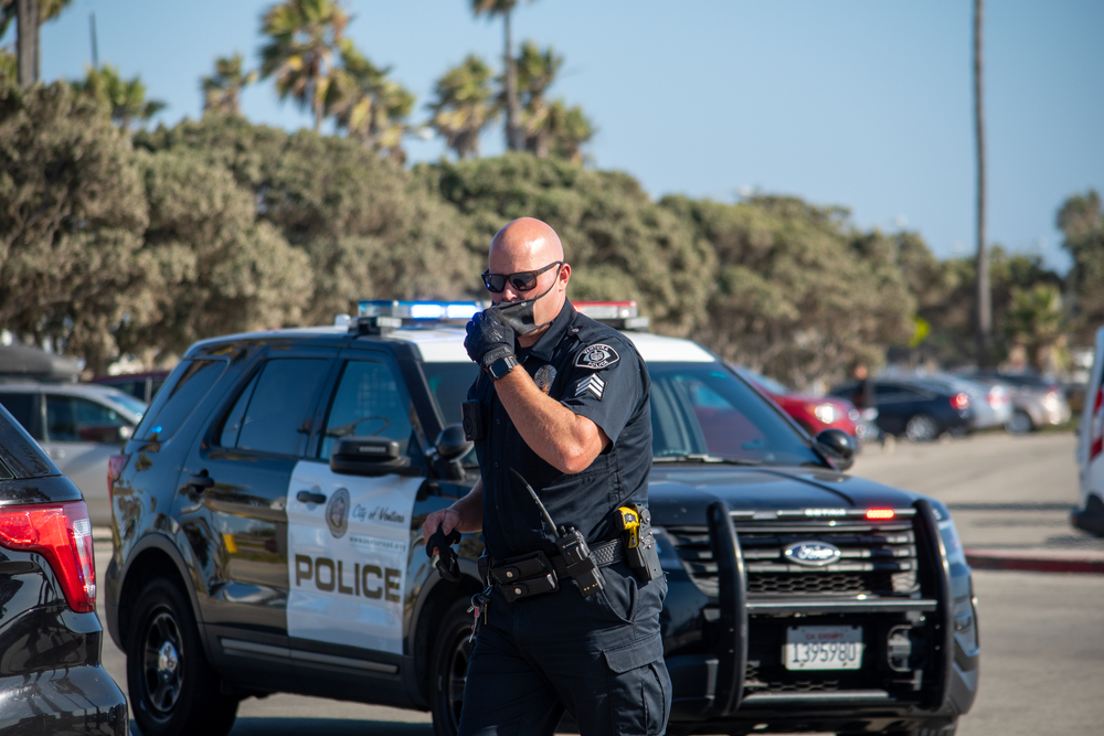 An officer from the City of Ventura Police Department exits his vehicle to conduct a search of a suspect's vehicle at Ventura Harbor.