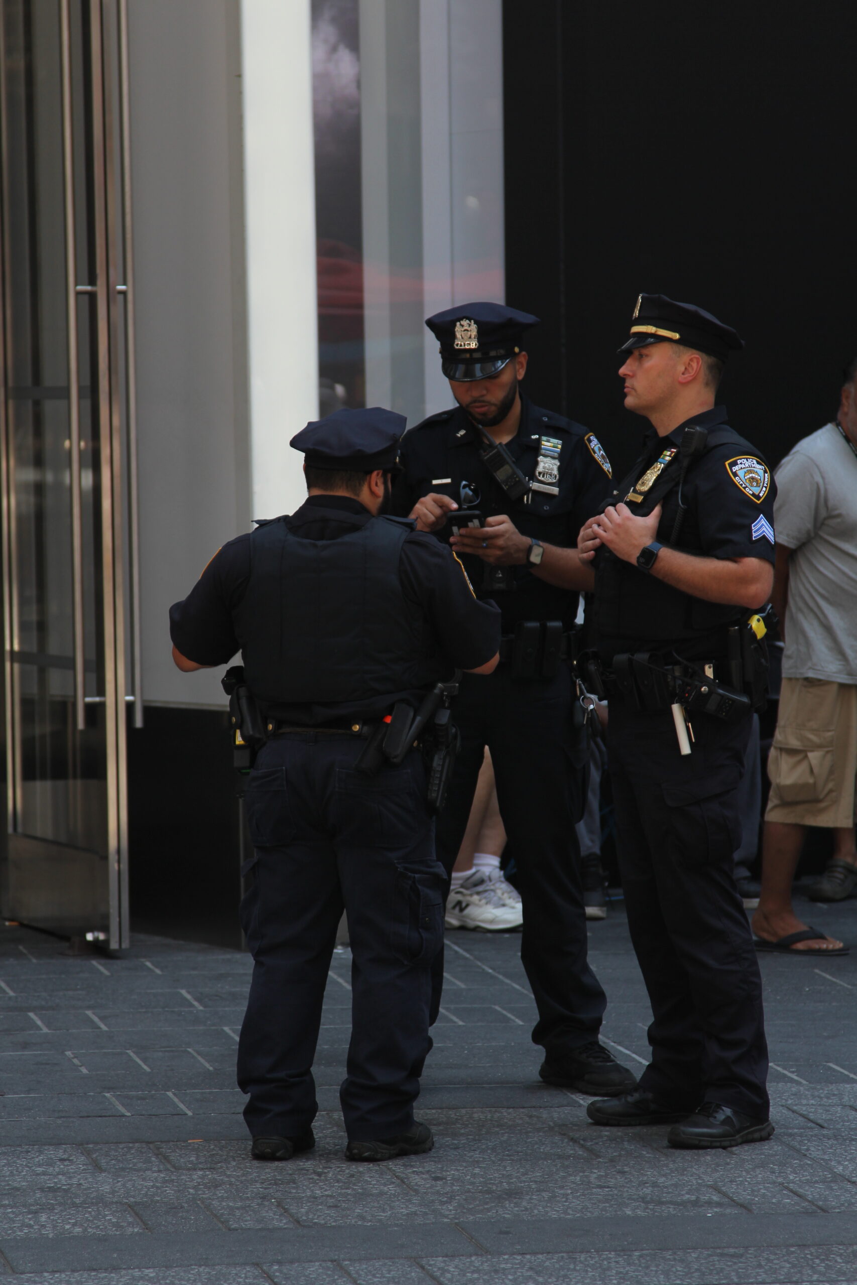 What Is a Police Welfare Check? What Happens Next 1 Several NYPD officers conferring near a building entrance