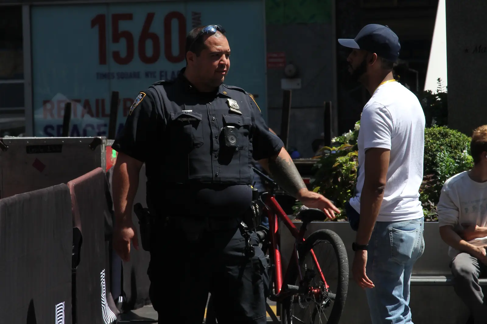 NYPD officer speaking with a civilian on a New York City street