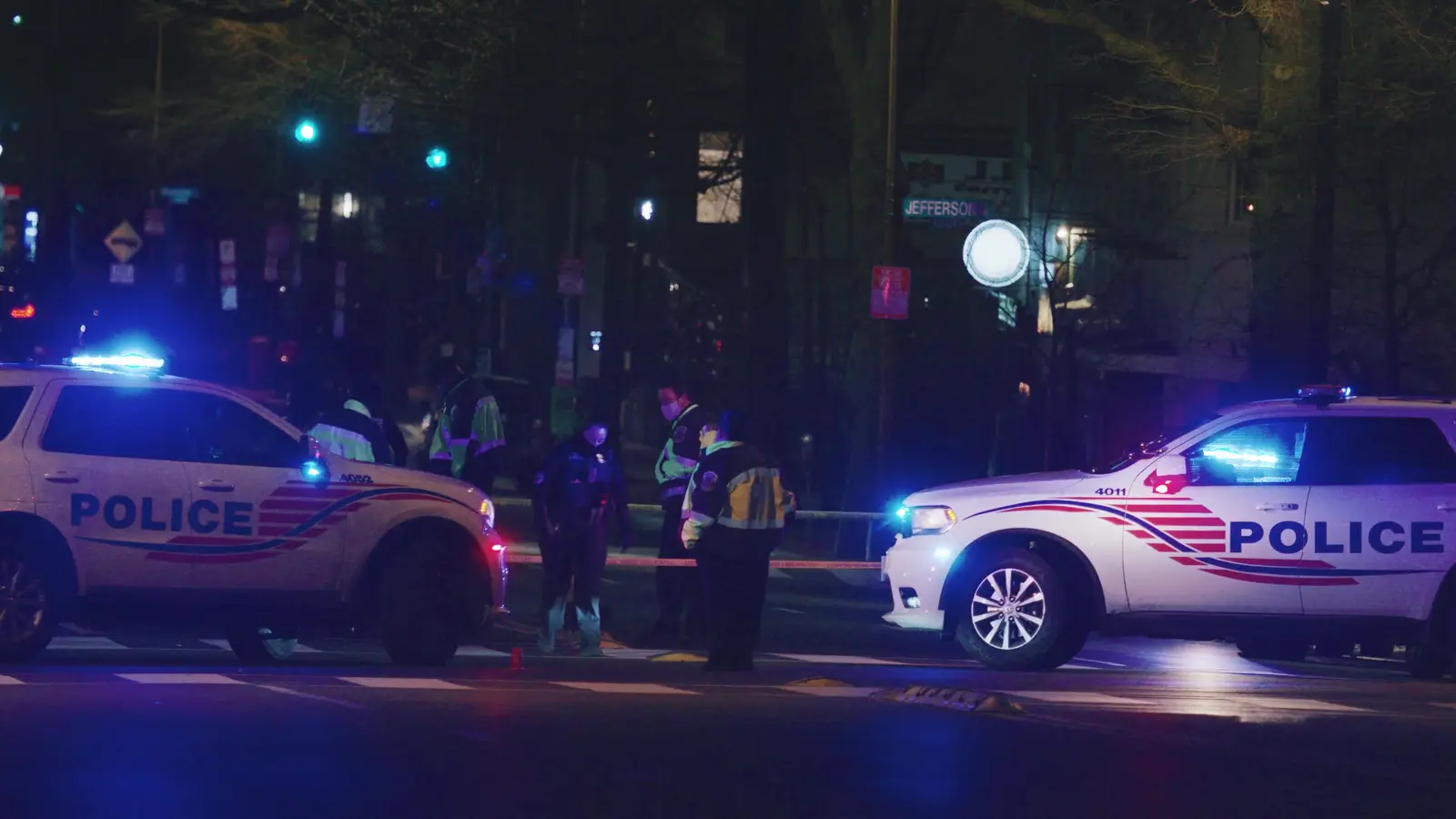 Police Tape Meaning: Colors, Rules and Crime Scenes 1 Marked police SUVs and officers behind scene tape at night