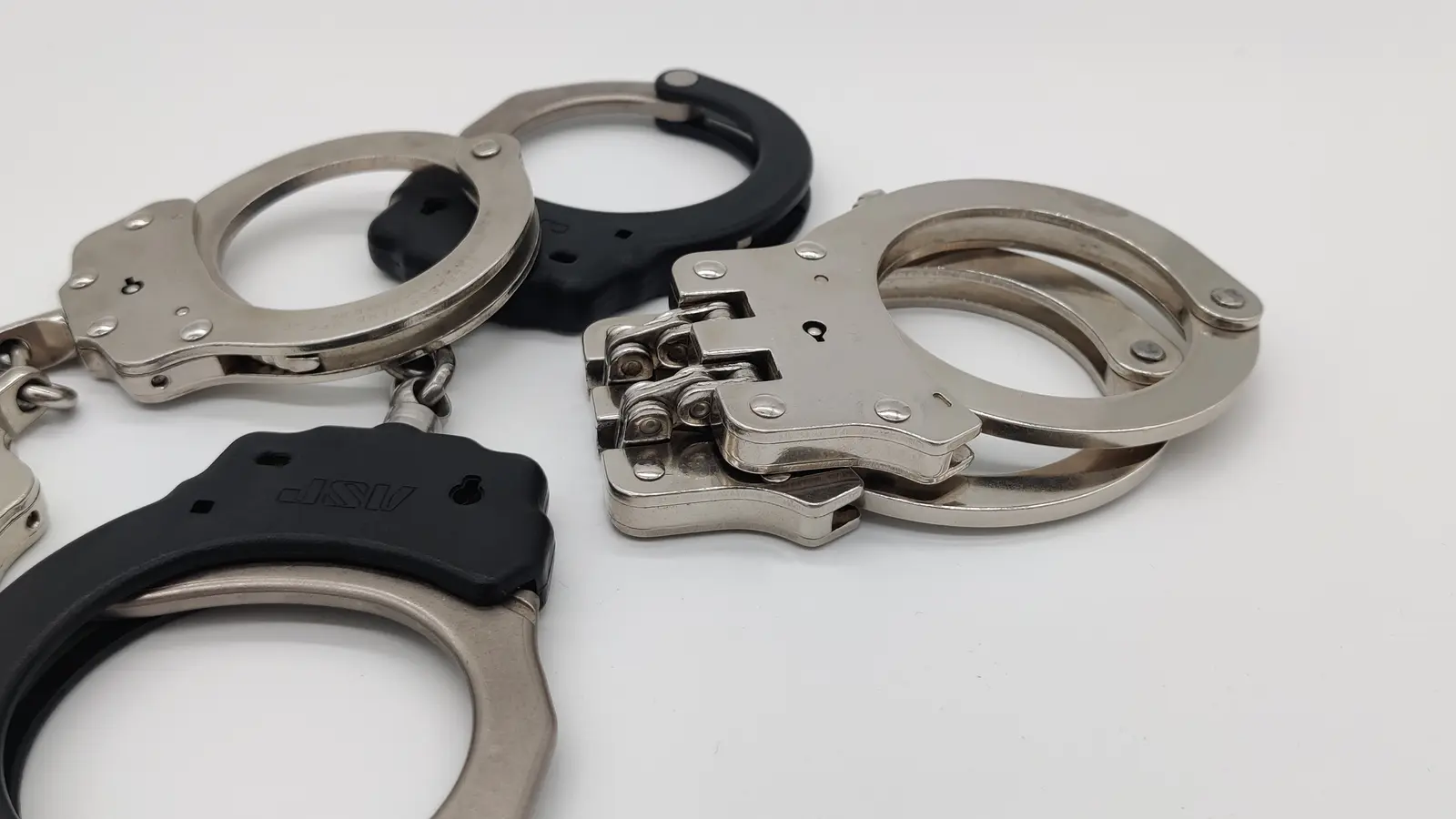 Several chain and hinged handcuffs arranged for inspection and maintenance