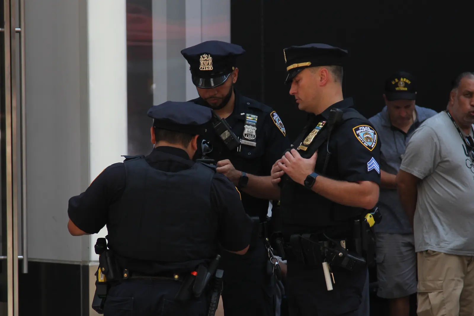 Three NYPD officers conferring during an outdoor assignment in New York City