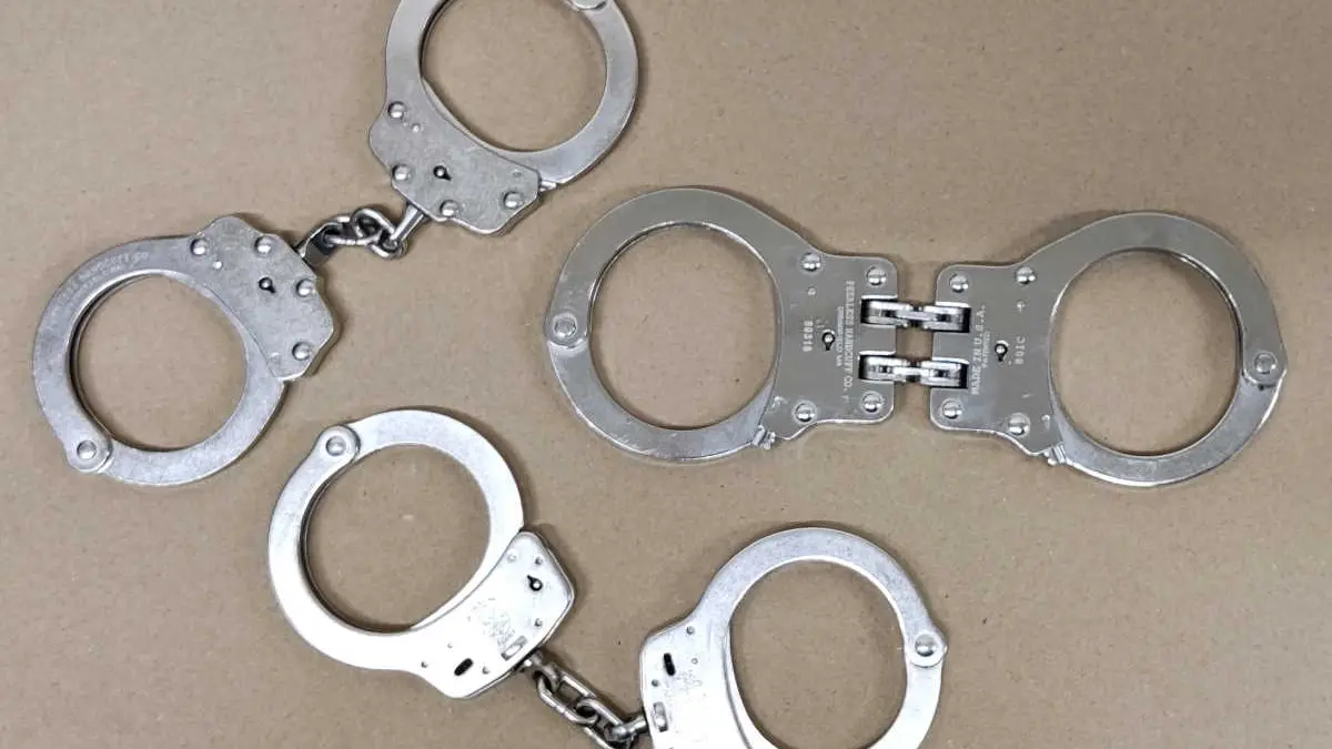 Three chain and hinged handcuff designs arranged for comparison